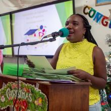 Une femme parle sur un podium.